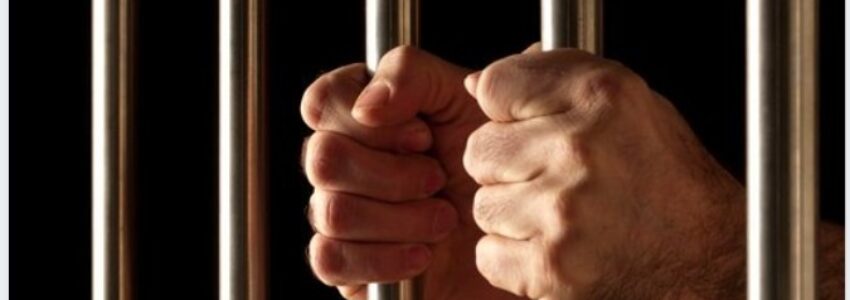 Tips for Dating Inmates_ An inmate holding jail bars.