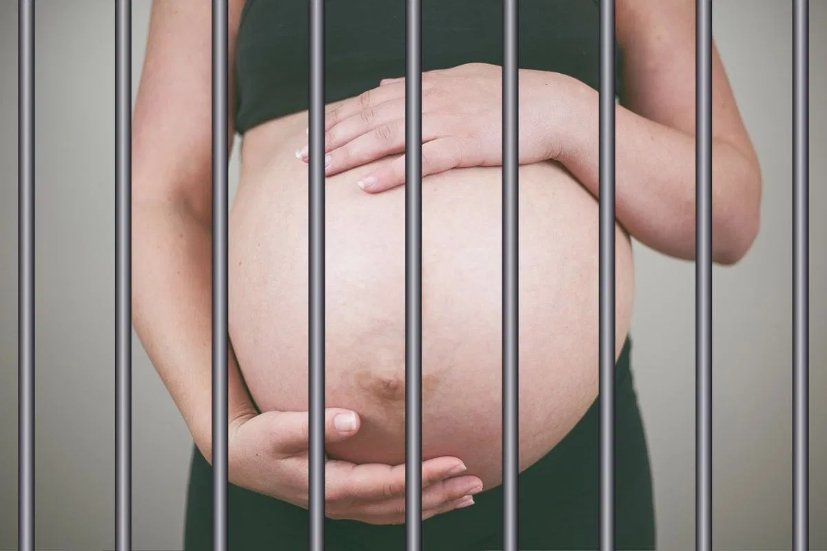 A pregnant woman behind bars.