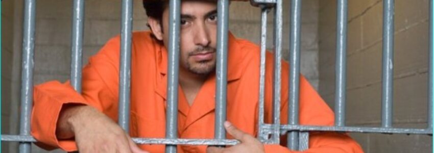 An inmate leaning on his jail cell bars