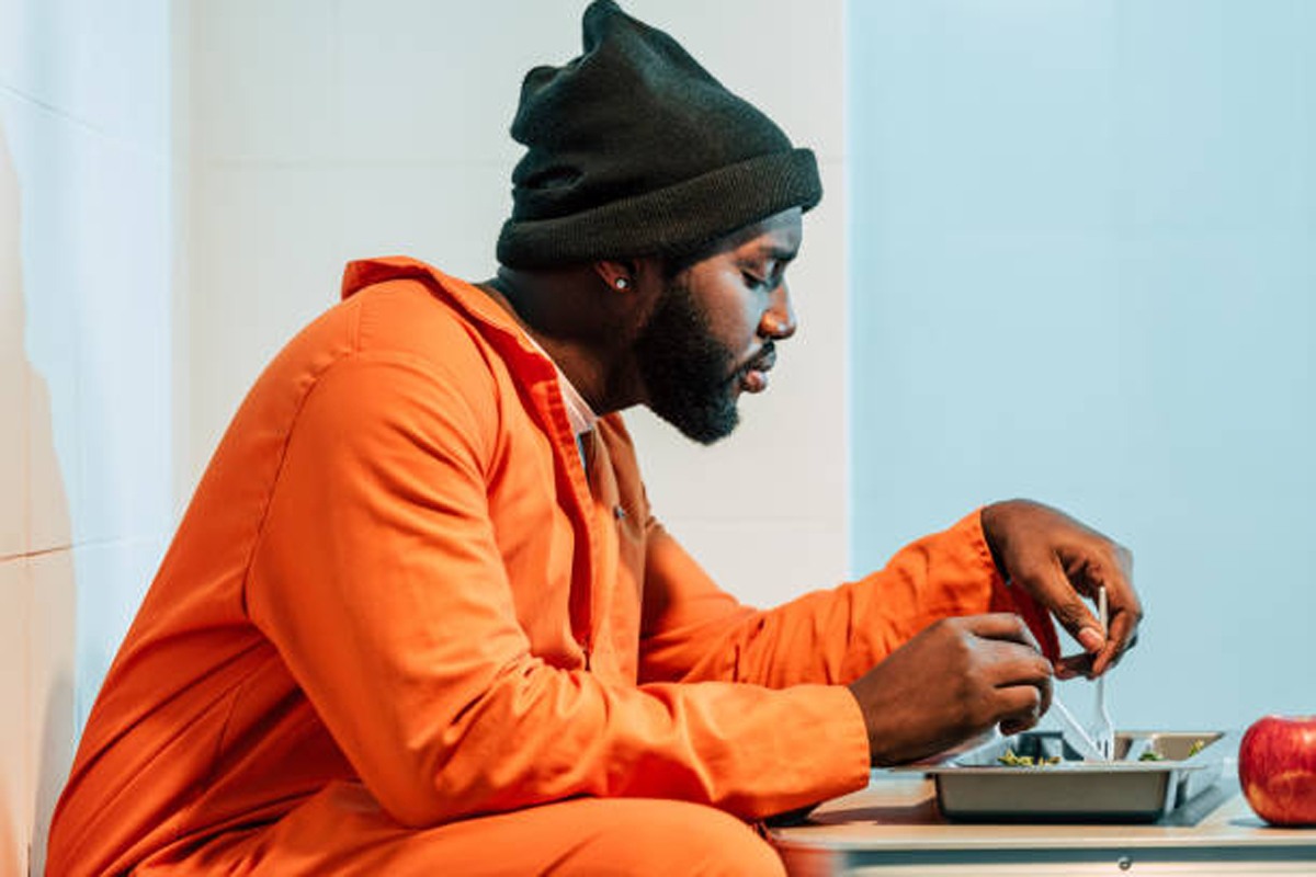 A prisoner eating his food.