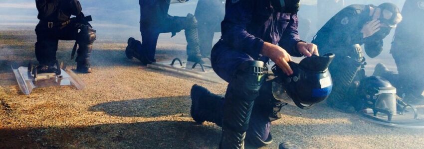 Police officers putting on their gas masks in preparation for a deadly prison riot.