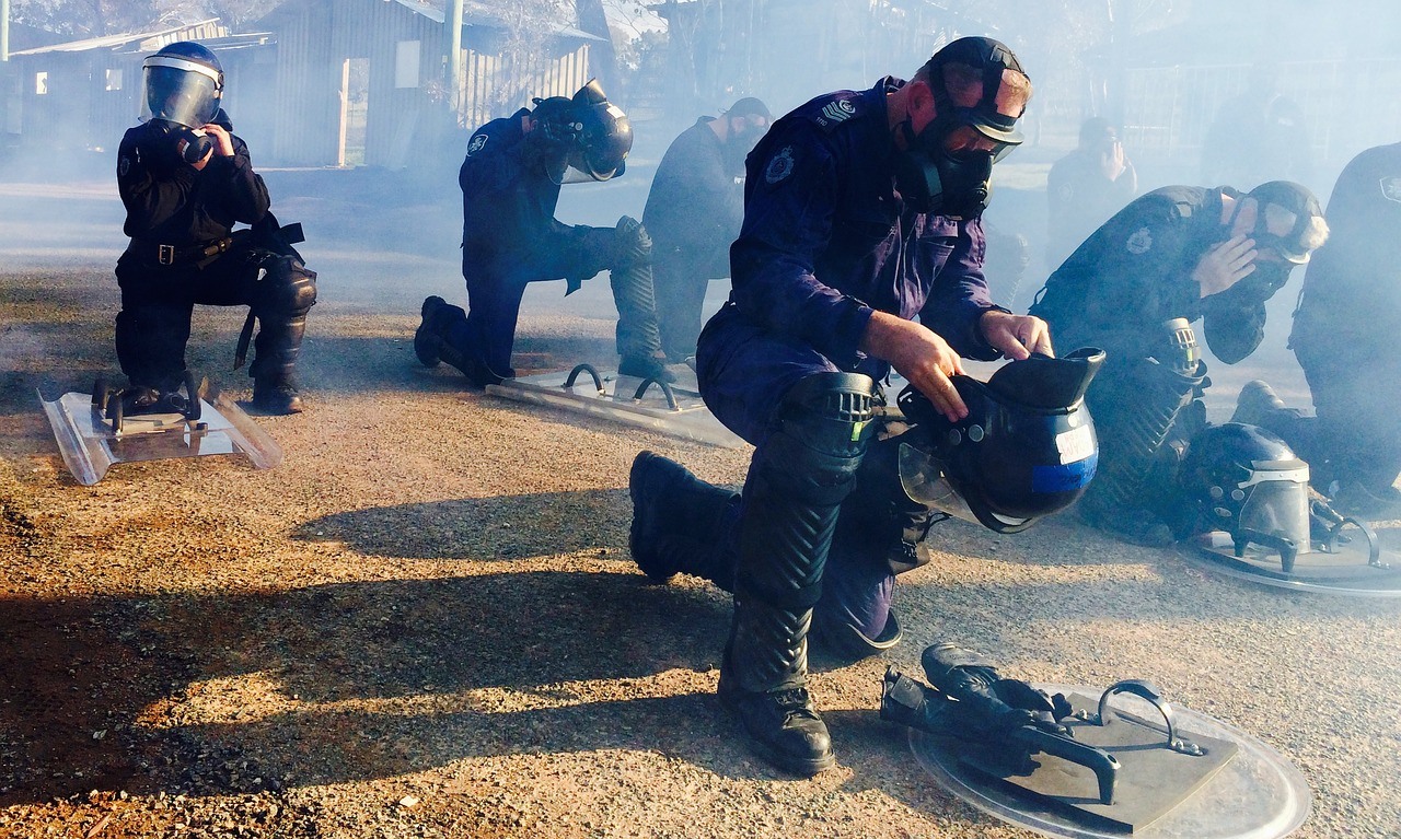 Police officers putting on their gas masks in preparation for a deadly prison riot.