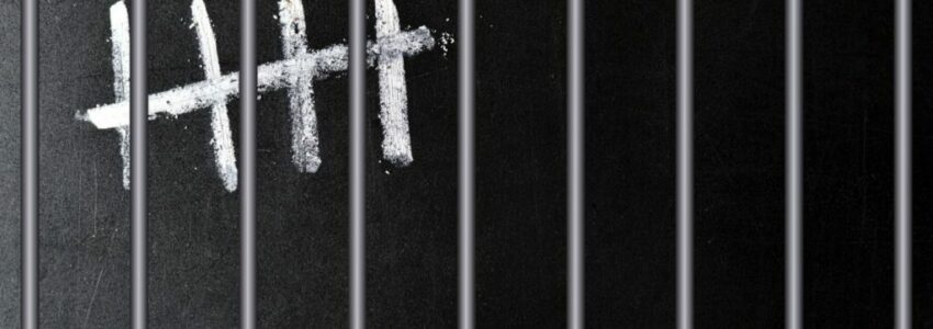 A 5-strike sign behind steel bars symbolizing a countdown of prison sentence.