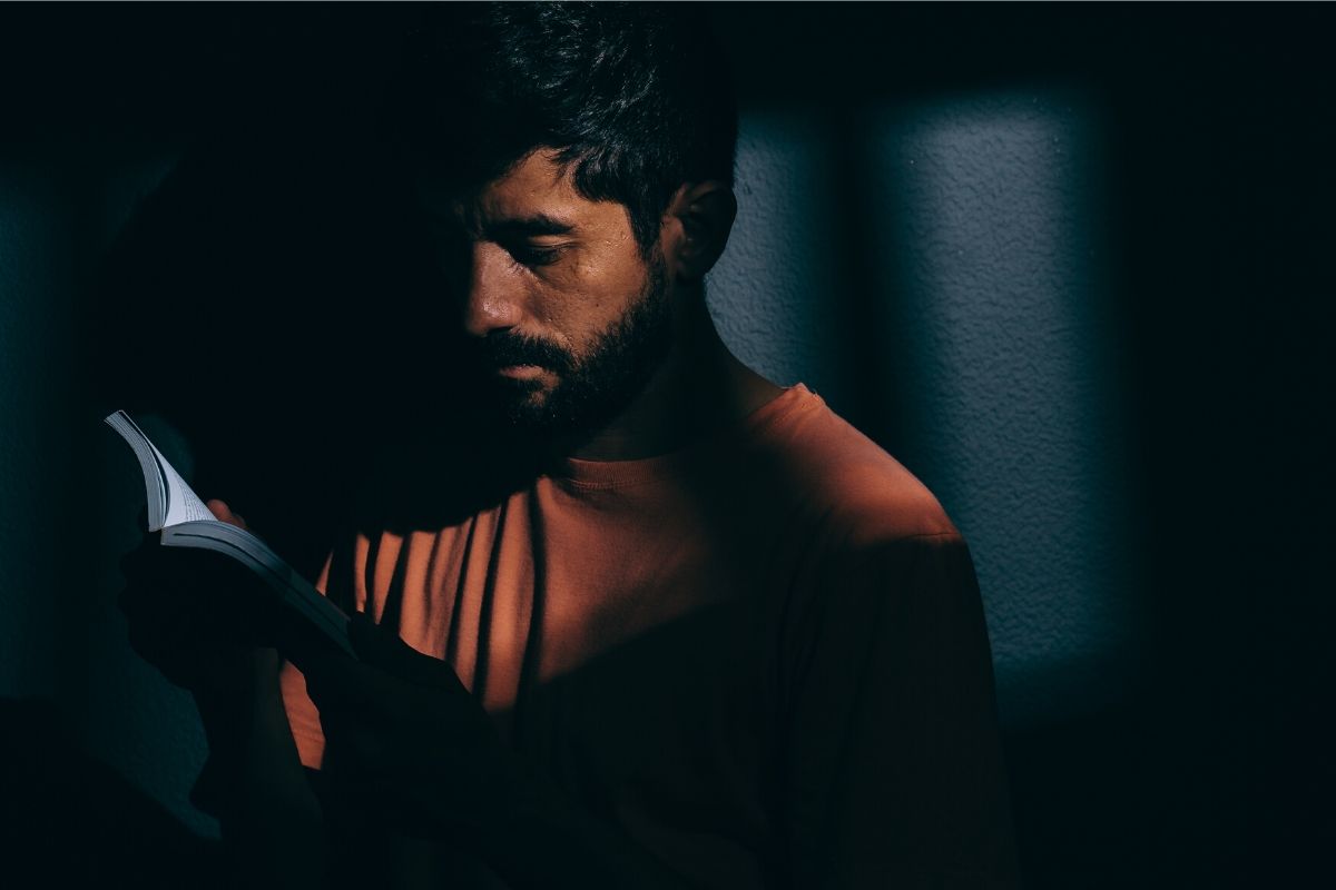 An inmate reading a book in prison.