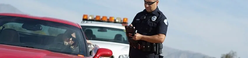 A policeman issuing a ticket for traffic violation.