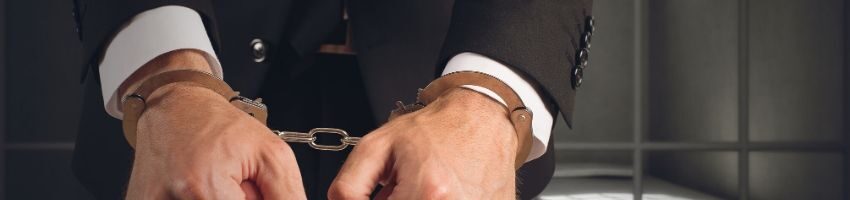 A white-collar prisoner in handcuffs.