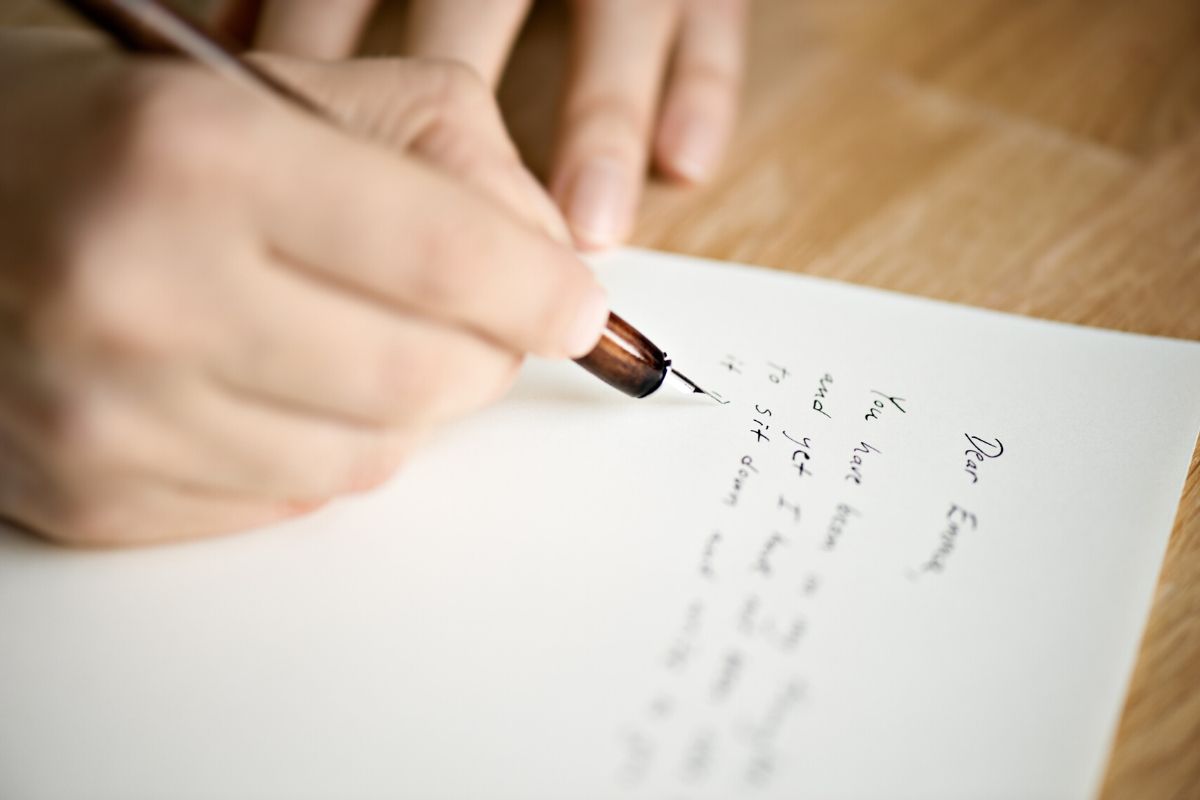 Someone writing a letter to his pen pal in prison.