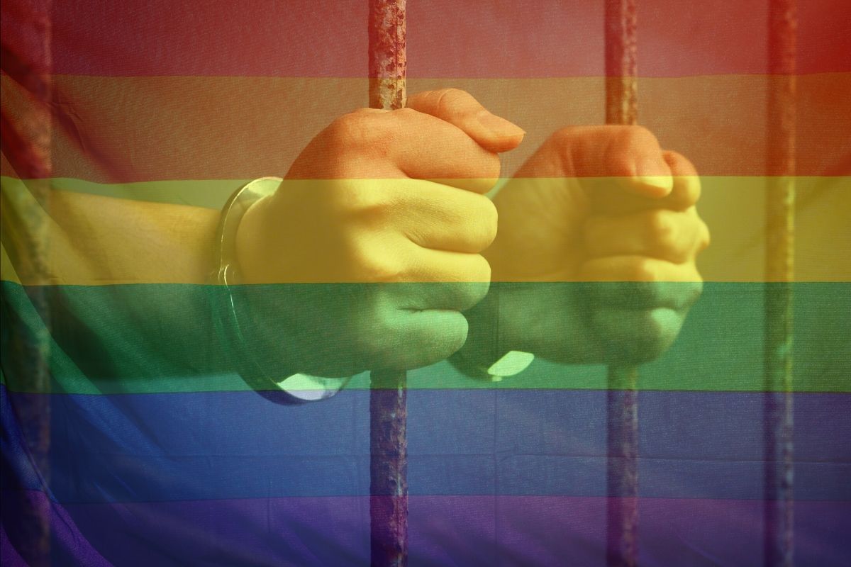 A gay inmate is holding onto the prison bars.