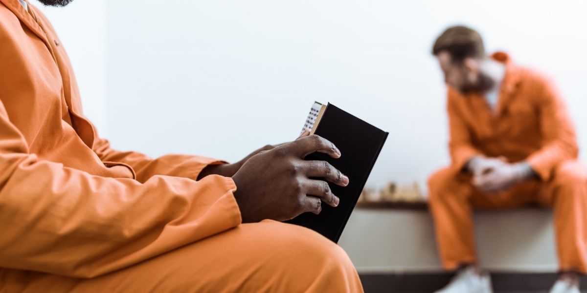 Image of a american prisoner reading the book of Malcolm X in Prison