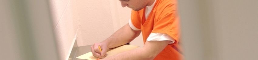 Inmate writing a letter to judge in cell