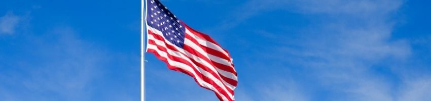 An American flag sits on a pole blowing in the wind.