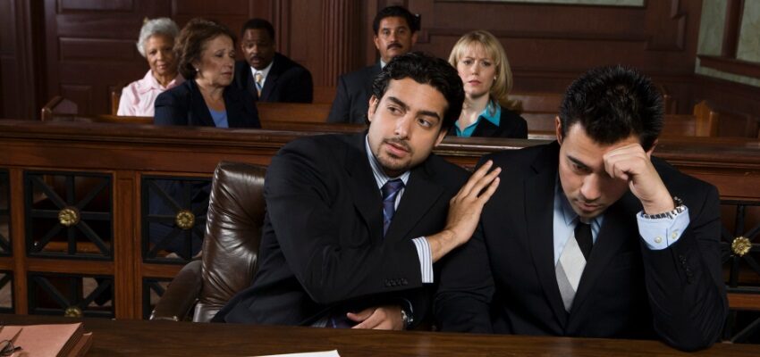 A lawyer tries to calm the defendant down as they try to change the charge after the arraignment.