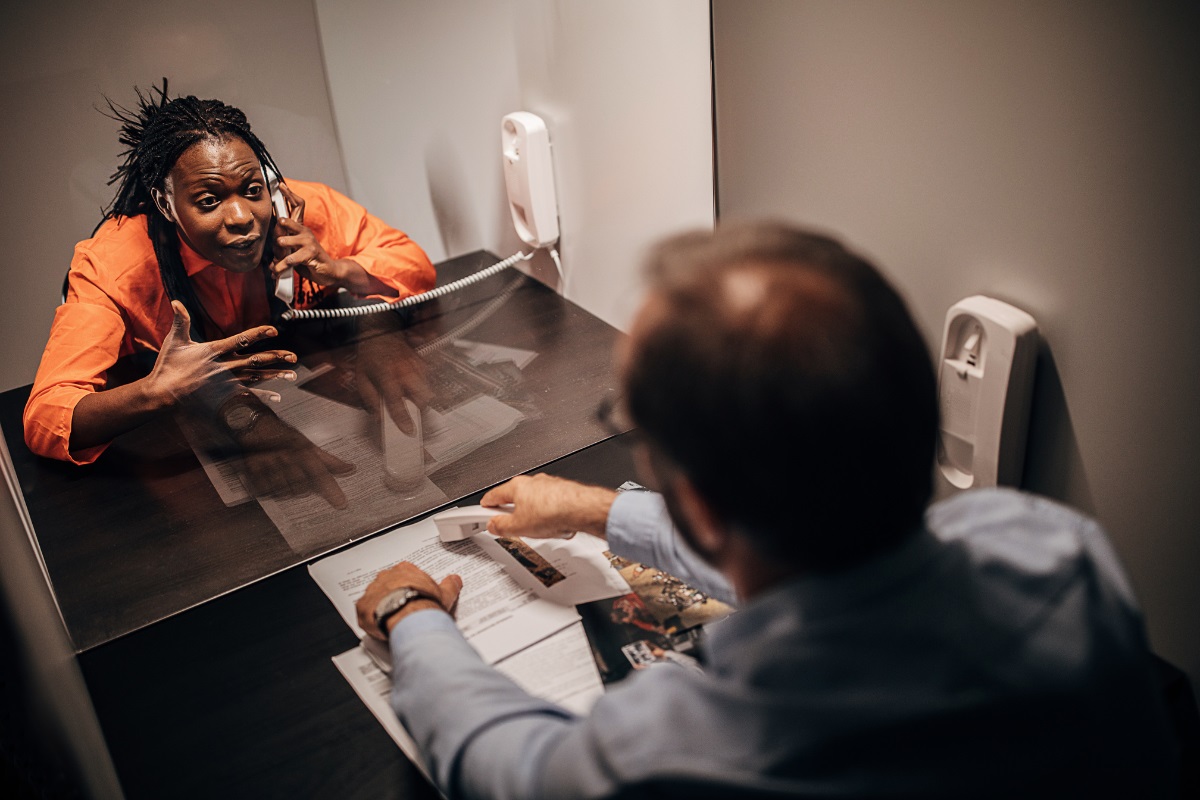 A female inmate talks to her lawyer.