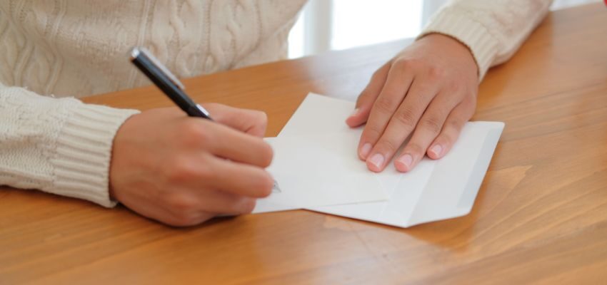 A person is starting to write a letter to an inmate.