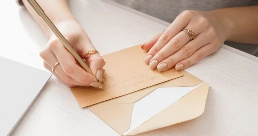 A woman is writing a letter to an inmate.