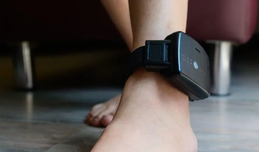 A person is wearing an ankle monitor.