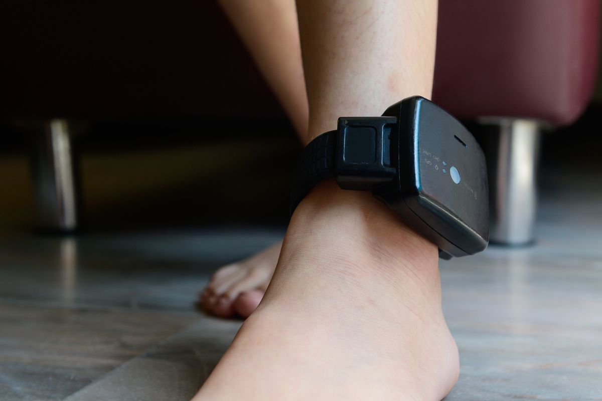 A person is wearing an ankle monitor.