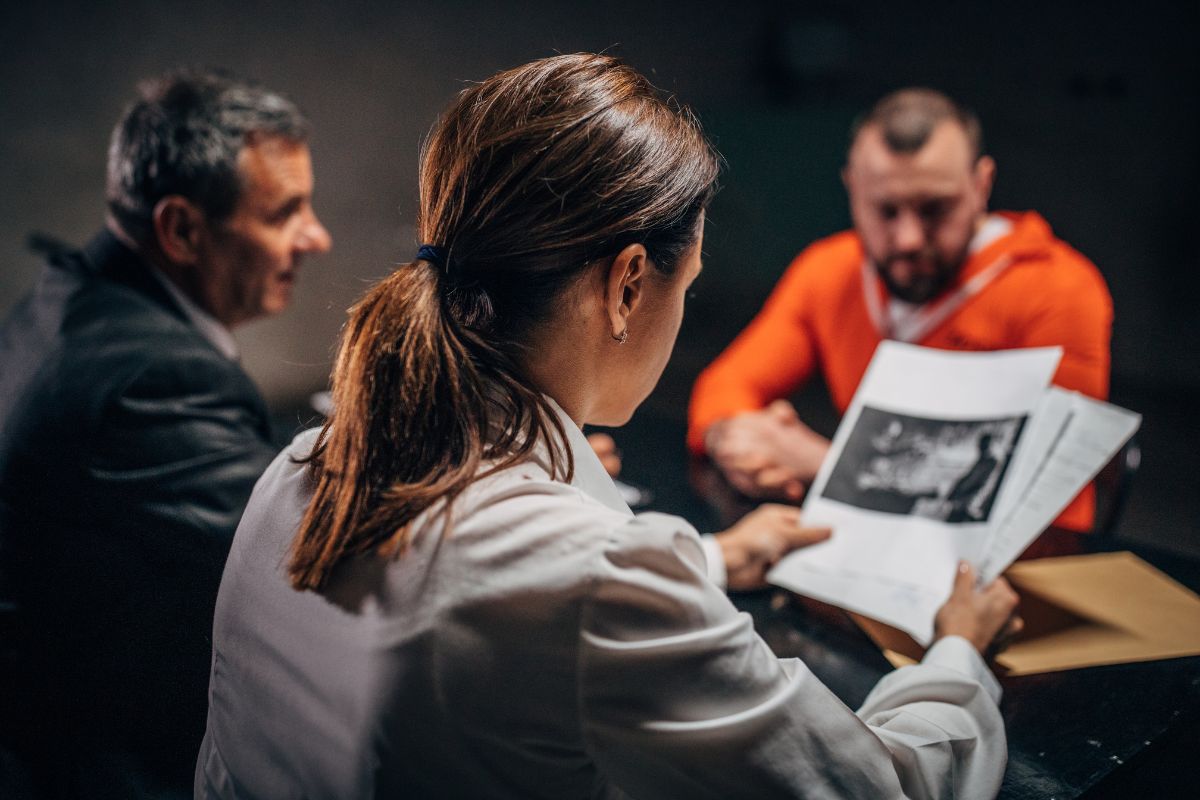 A room with a prisoner and two lawyers discussing protective custody